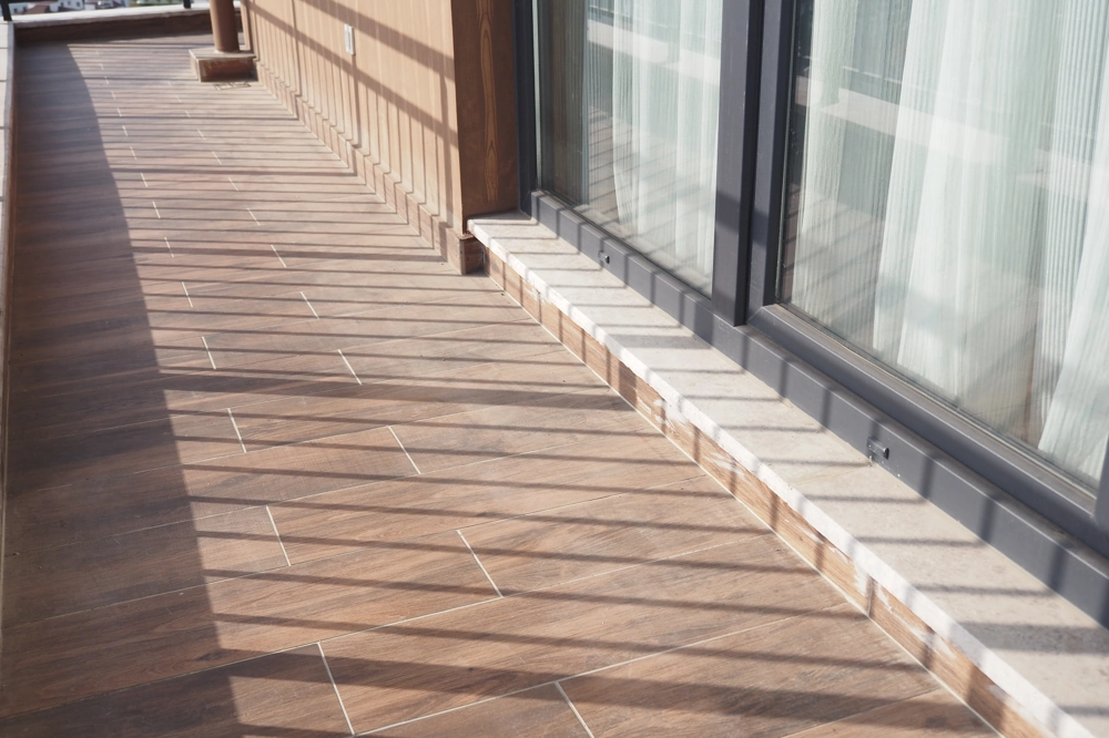 Tarasy z płyt ceramicznych z drewnopodobnym wzorem i przeszklonymi drzwiami
